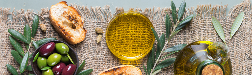 Picture of a bowl of Extra Virgin Olive Oil, surrounded by olives